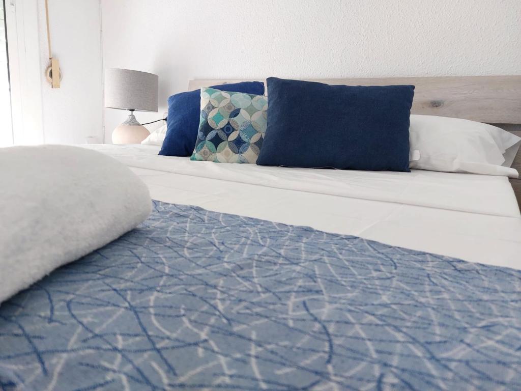 阿利坎特SDH apartments的一张带蓝色和白色枕头的床