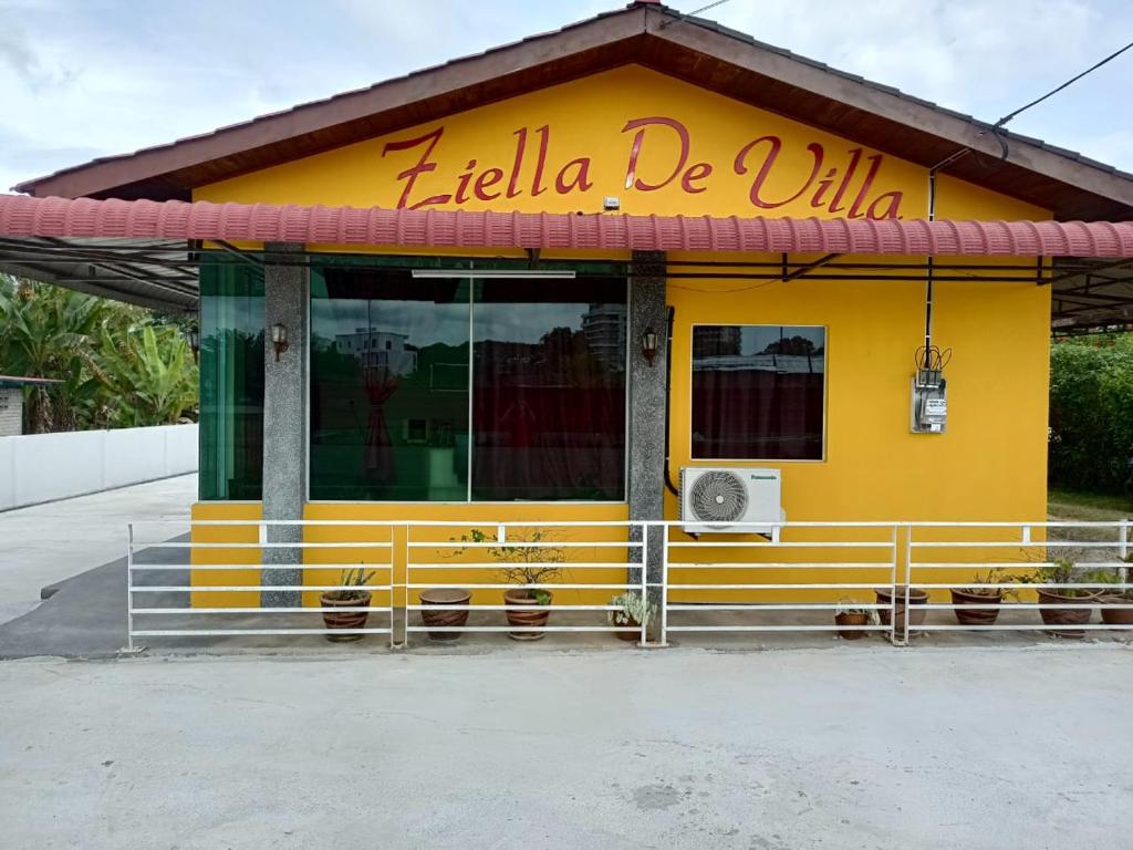 珍南海滩Ziella De Villa的黄色的建筑,上面有读贝拉的标志
