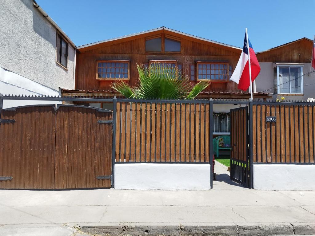 圣地亚哥太阳和月亮旅舍的一座带木栅栏和旗帜的房子