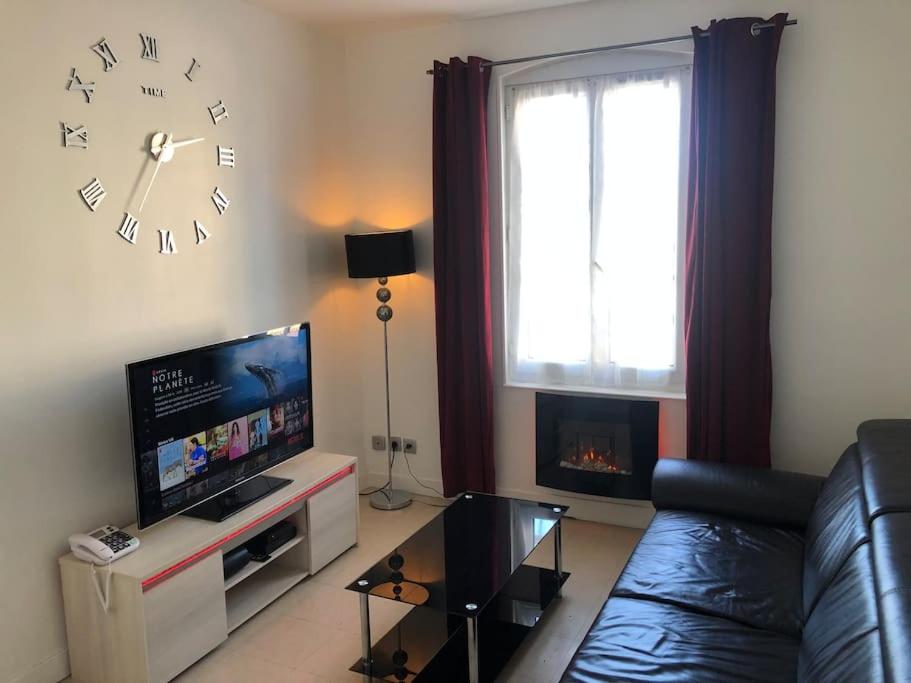 克雷伊Appartement 3 pièces 60M2 en face la gare de creil的客厅配有沙发和墙上的时钟