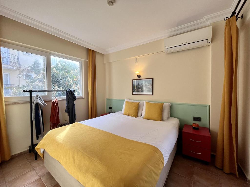 费特希耶十大公寓酒店的一间卧室配有一张带黄色床单的大床和窗户。