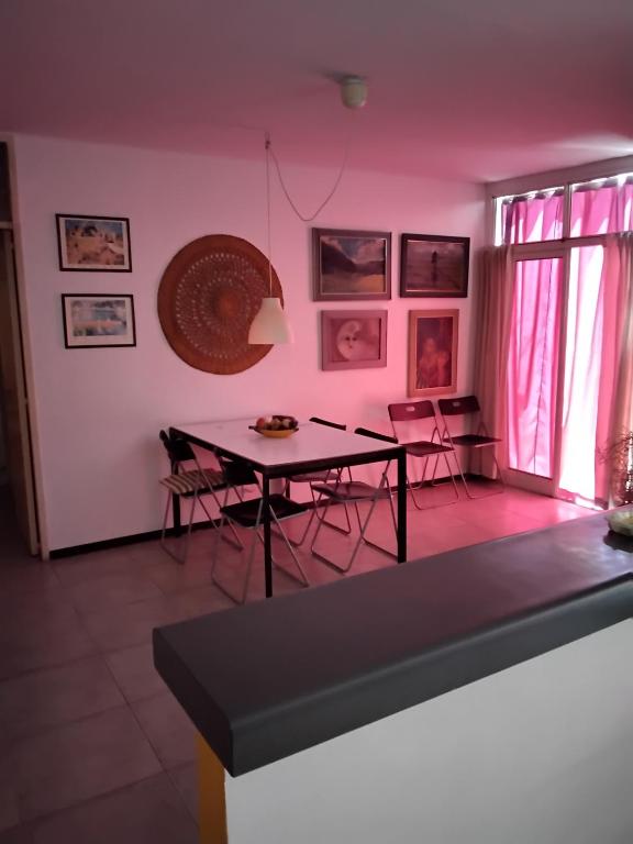 戈多伊克鲁斯Maria Delicia的用餐室配有桌椅和粉红色的墙壁