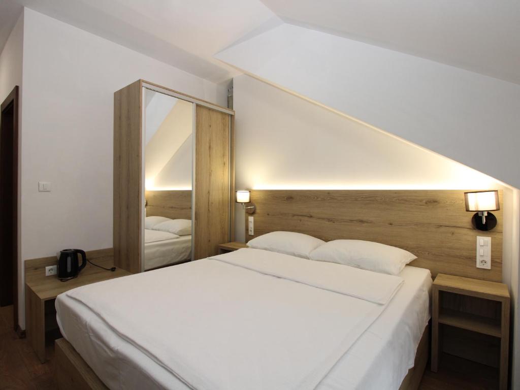萨拉热窝Vila Alexandra的卧室配有白色的床和大镜子