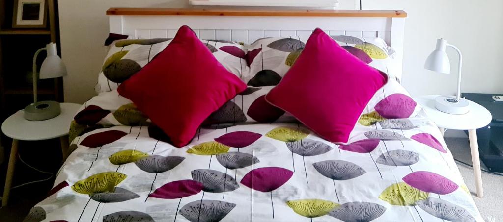 KintburyCharming Kintbury Cottage的床上有许多色彩缤纷的枕头