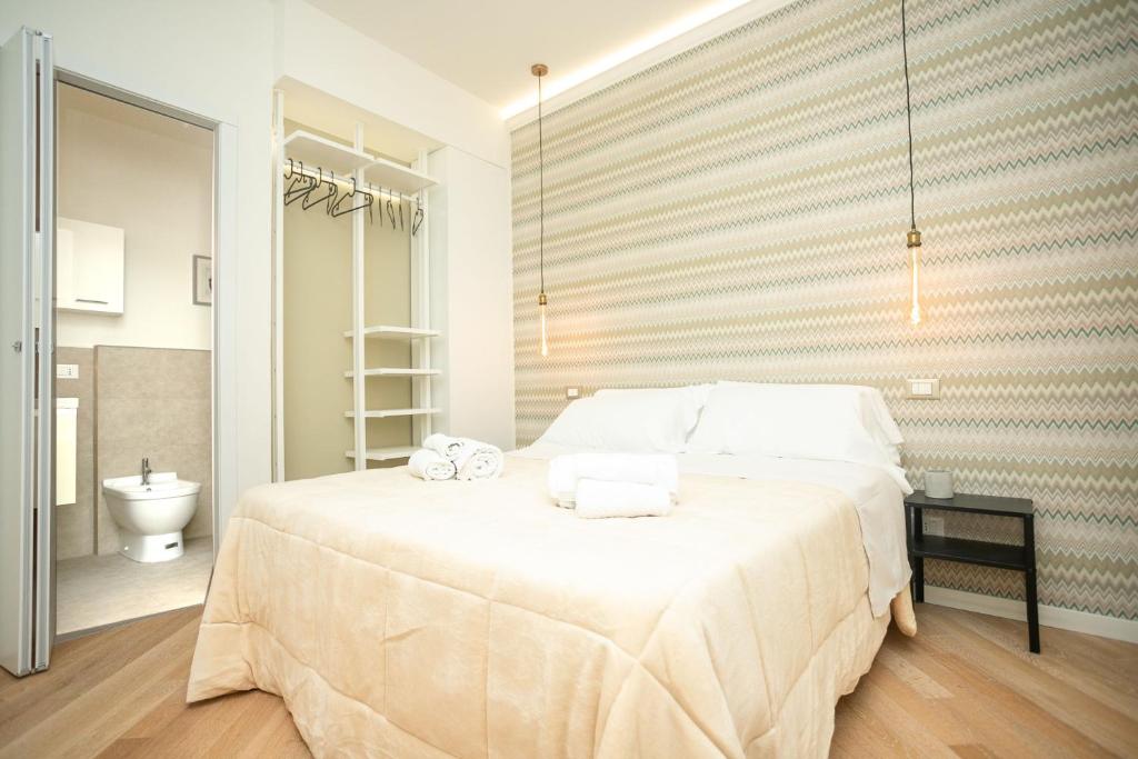 摩德纳Modena Centro Junior Suite的一间卧室配有一张大床和毛巾
