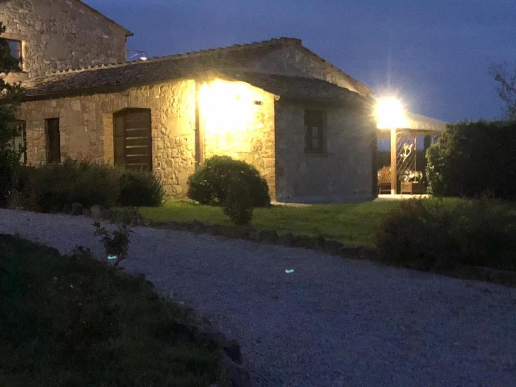 阿夏诺Country House Girasole Crete Senesi Vakantie Huis的夜晚有灯的石头房子