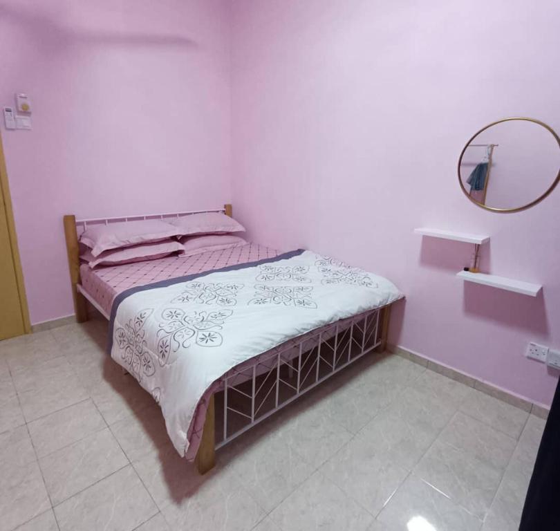 芙蓉NuReezal Homestay Seremban的白色客房的一张床位,配有镜子