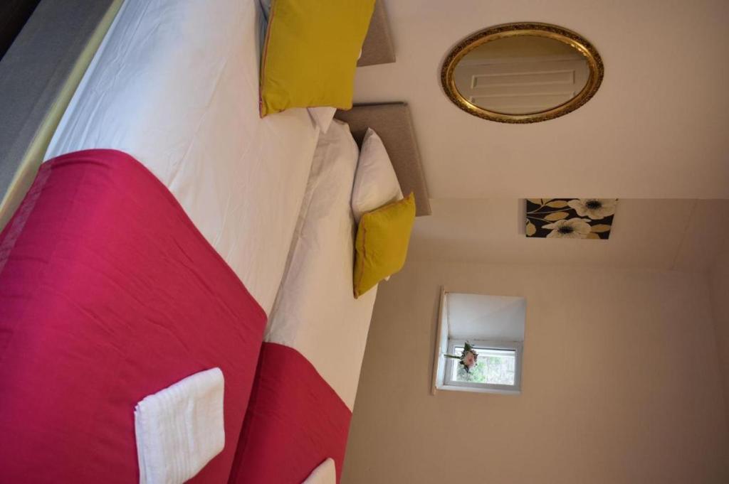 登比Braillen Suite- 2 bedroom with kitchenette and bathroom的一间卧室配有一张大床,提供红色和黄色枕头