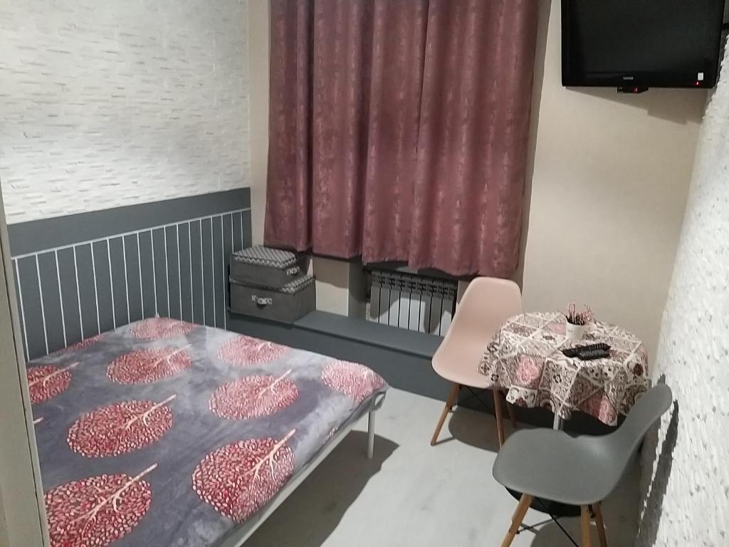 哈尔科夫Міні готель на Костюринському的小房间设有床、桌子和椅子
