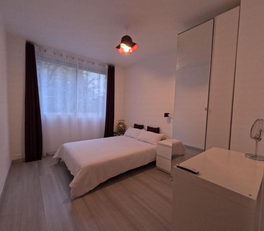 里昂Calme chambre Maya的白色的卧室设有床和窗户
