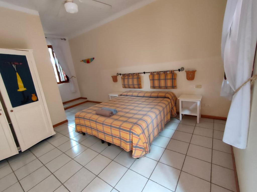 萨尔雷Estoril Hotel - Apartments的卧室配有1张床,铺有瓷砖地板。