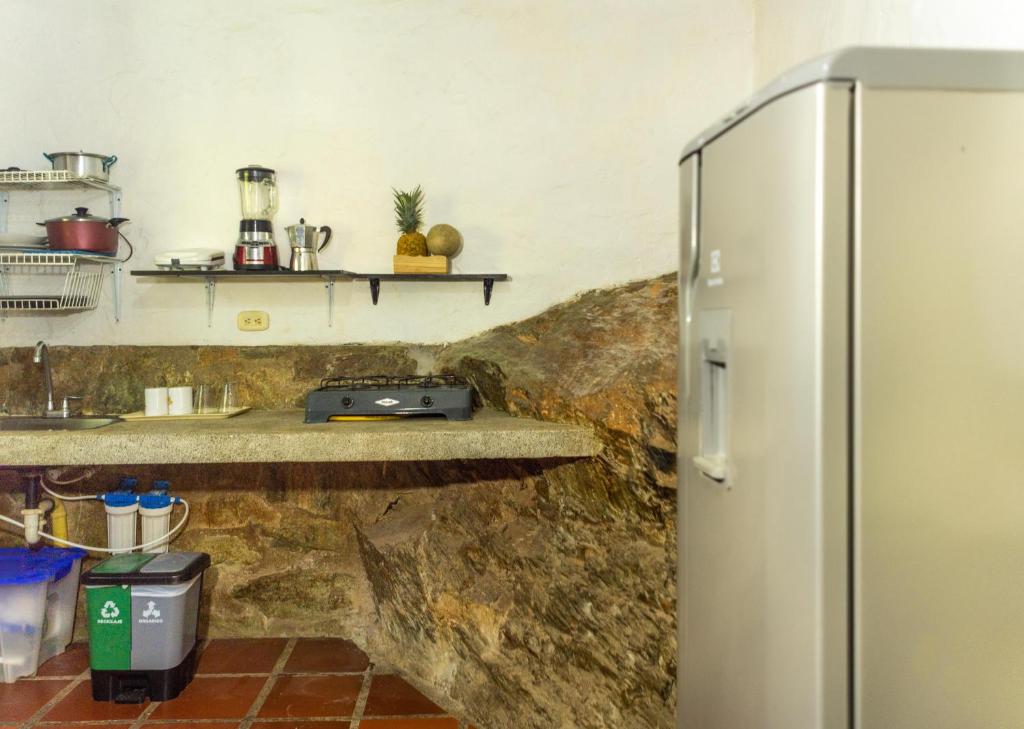 塔甘加Casa de Piedra Taganga的厨房设有石墙,配有冰箱