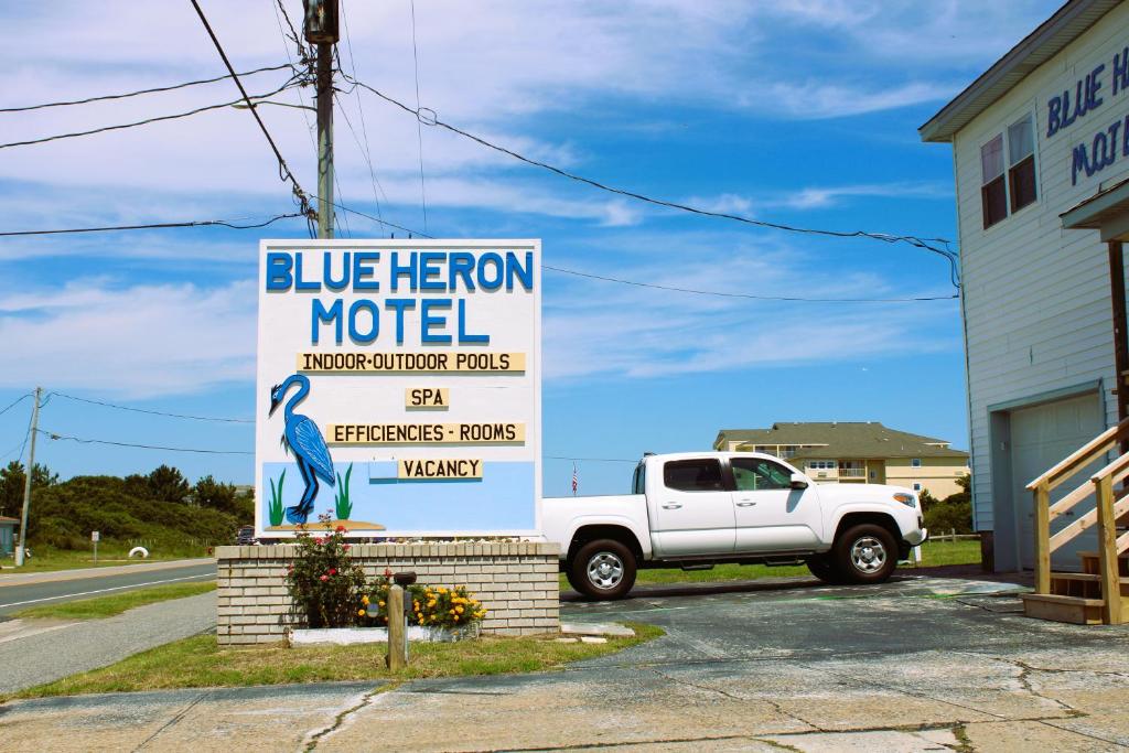 纳格斯黑德Blue Heron Motel的一辆停在蓝色英雄汽车旅馆标志旁边的卡车