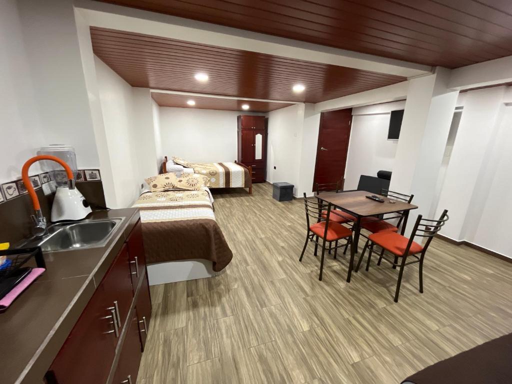 巴尼奥斯Bello apartamento en Baños de Agua Santa的卧室配有一张床和一张桌子及椅子