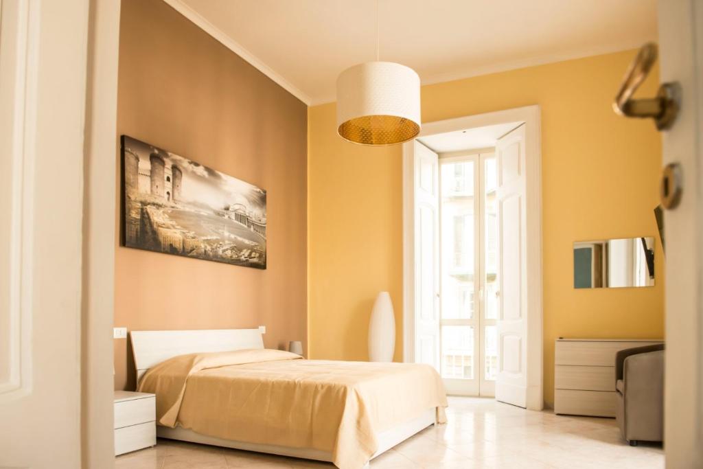 那不勒斯Maria Marì house的卧室拥有黄色的墙壁,设有一张床和窗户。