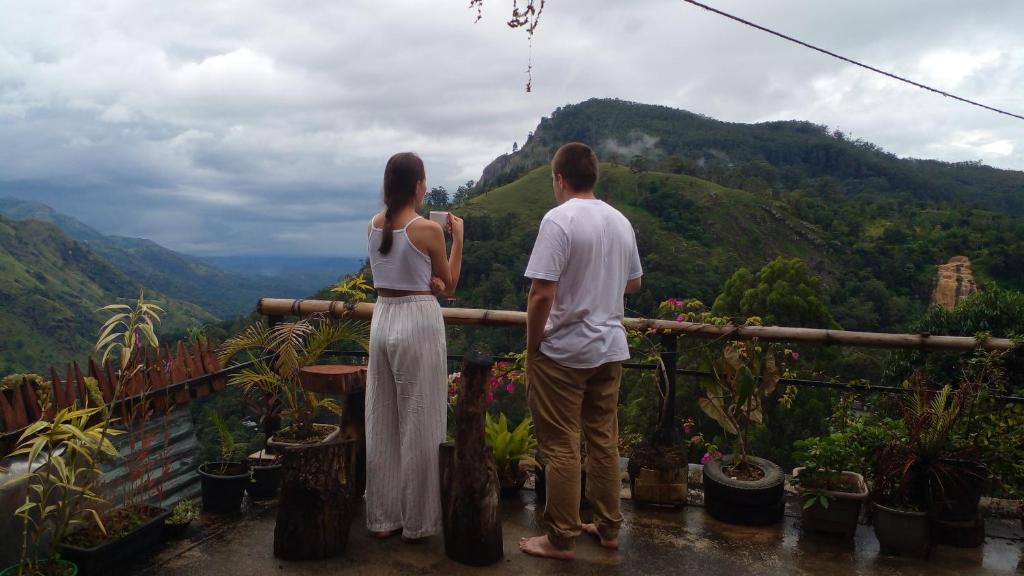 埃拉Secret View Homestay Ella的男人和女人站在一个山景阳台上