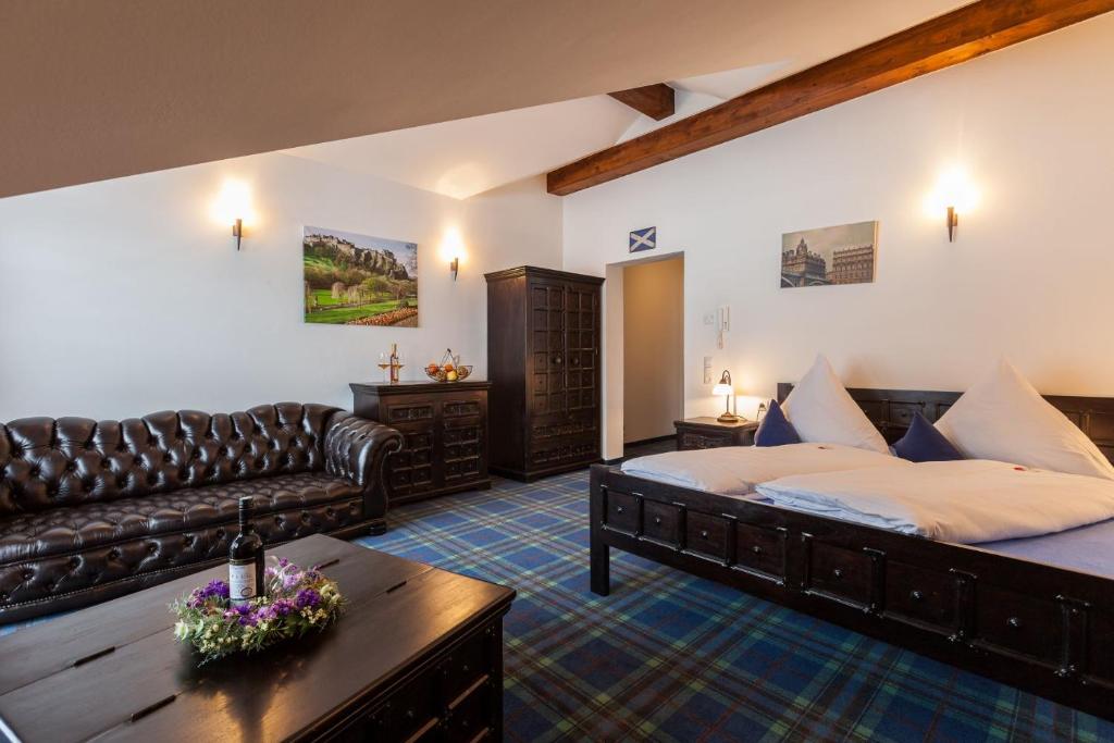 福森Vitusfort Doppelzimmer Edinburgh的一间卧室配有一张床、一张沙发和一张桌子