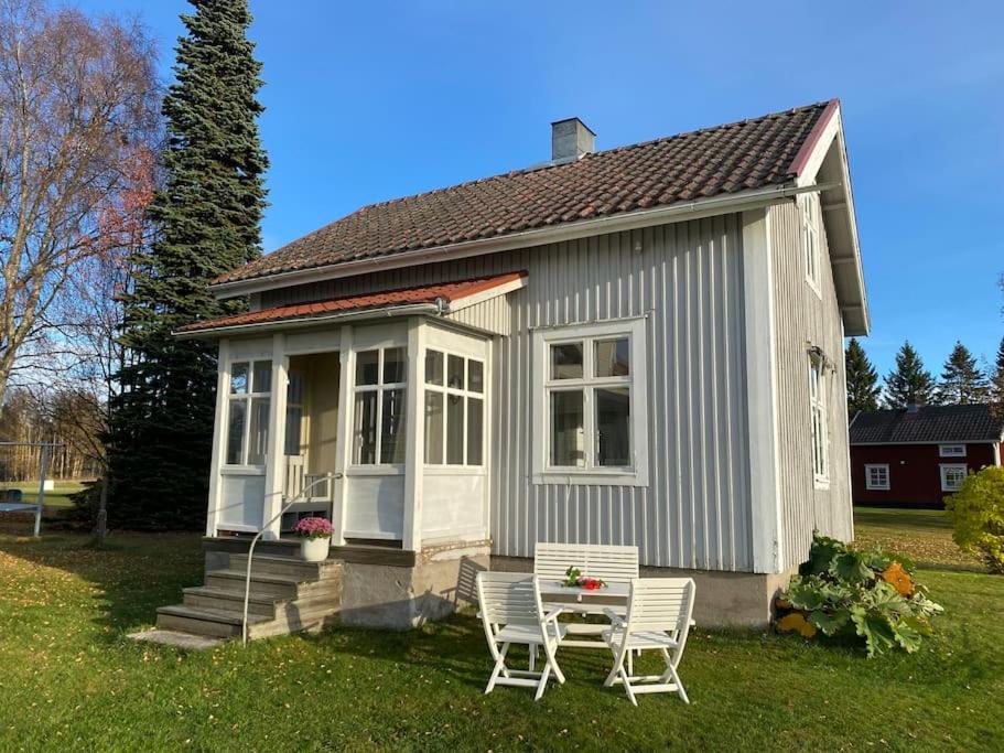 NorrfjärdenCharmig stuga på bondgård的院子内带两把椅子和一张桌子的小房子
