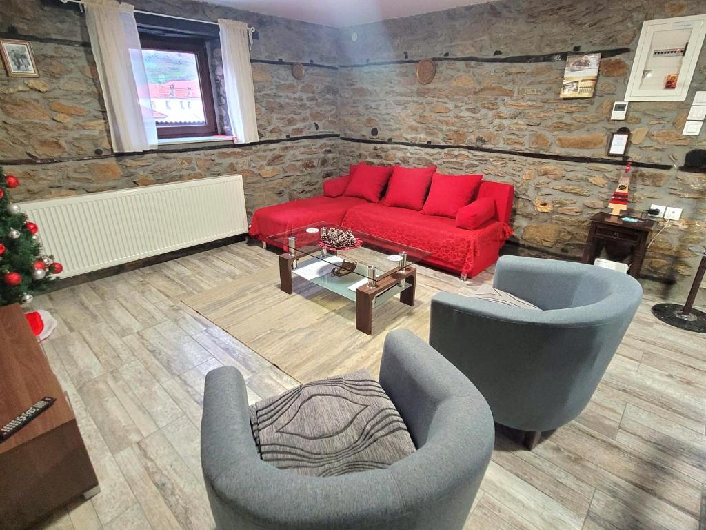 弗洛里纳Traditional Stone Villa "To Petrino"的客厅配有红色的沙发和两把椅子