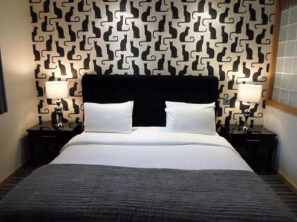 南特威奇柴郡之猫酒店的一间卧室配有一张大床、两个床头柜和两盏灯。
