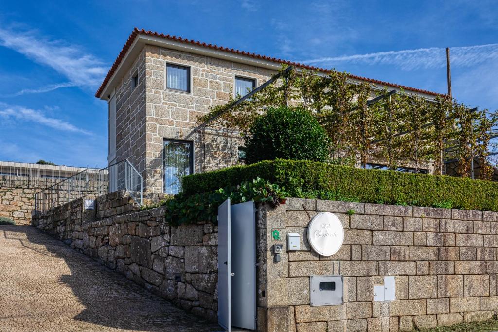 阿尔瓦伦加Casa do Soutinho的砖砌的建筑,石墙旁边是栅栏