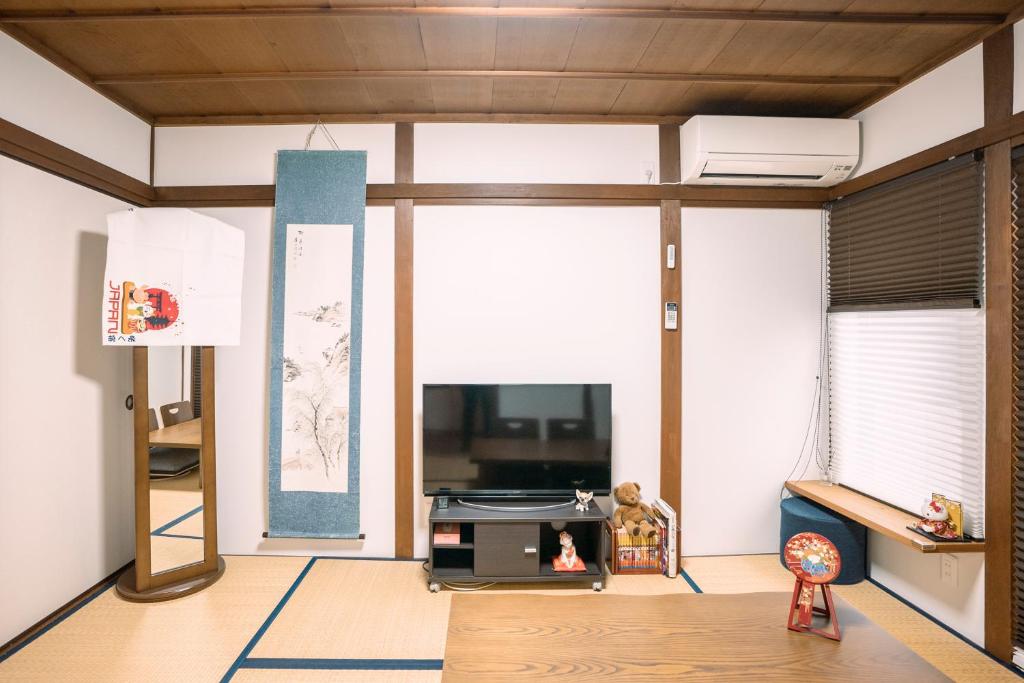 京都Tofukuji Saku Inn（东福寺咲く宿）的一间带电视和沙发的客厅