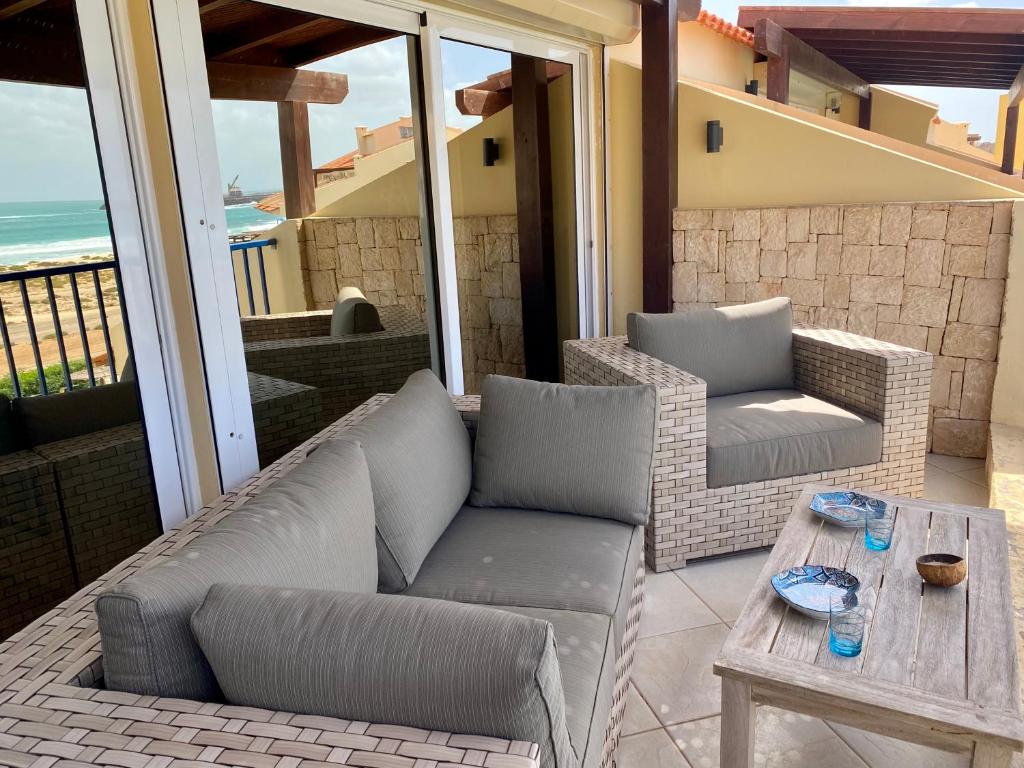萨尔雷Seaview Luxury Penthouse Mare的阳台的天井配有沙发和桌子