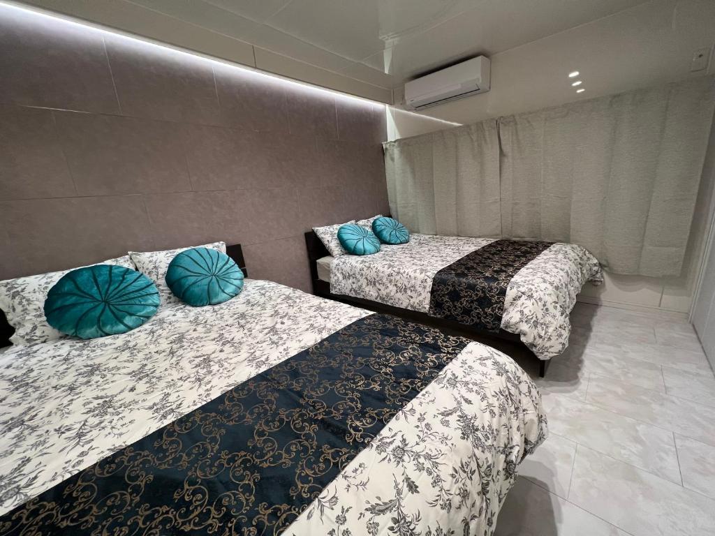 横滨雷屋旅馆的两张带蓝色枕头的床