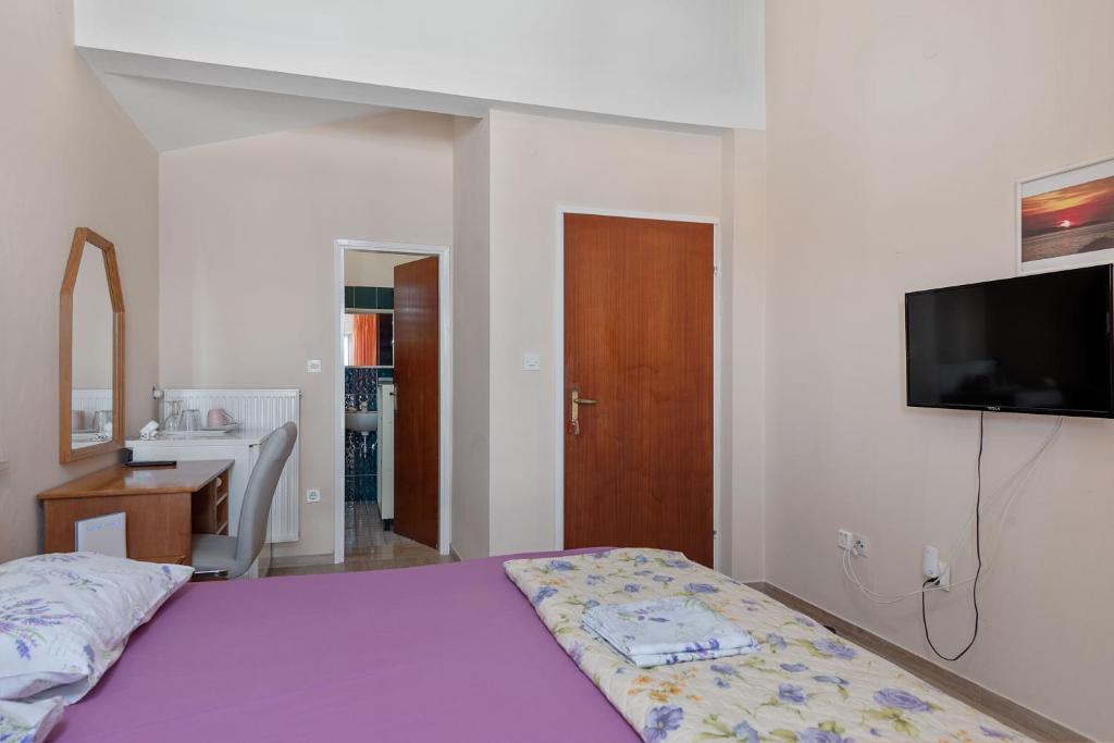 多布罗波尔贾纳Aparthotel Vila Danica的一间卧室配有一张紫色床,墙上配有电视