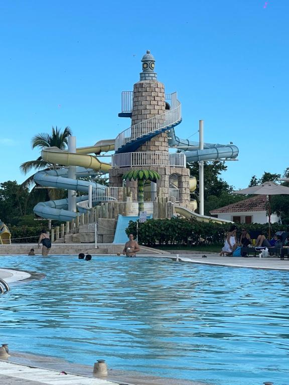 巴亚希贝Hotel Palmera Bayahibe的度假村的游泳池,带水滑梯
