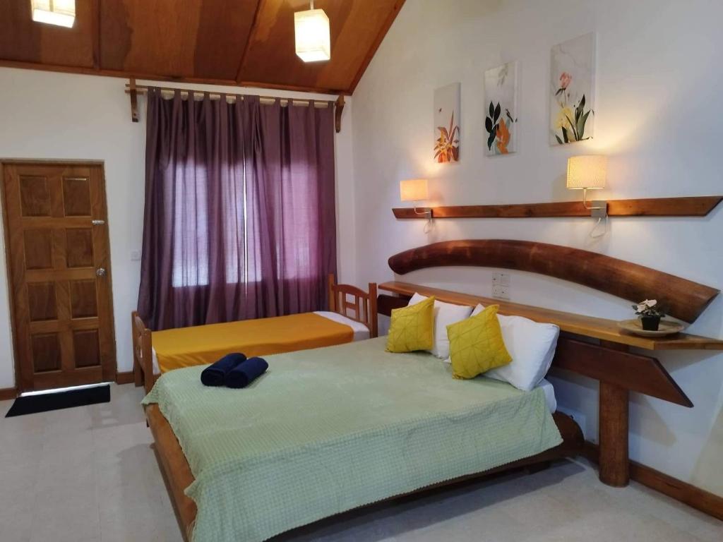 ThinadhooReethi Villa Vaavu Thinadhoo的一间卧室设有两张床,一扇门设有窗户