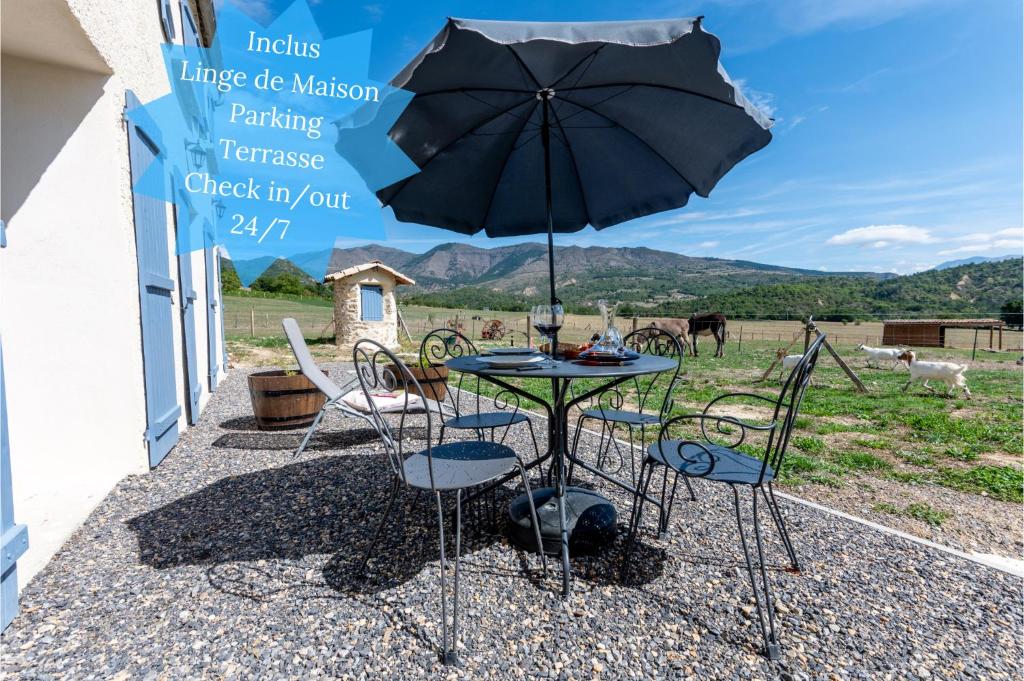 迪涅莱班Plaines-Provence Spa&Sauna的庭院内桌椅和遮阳伞