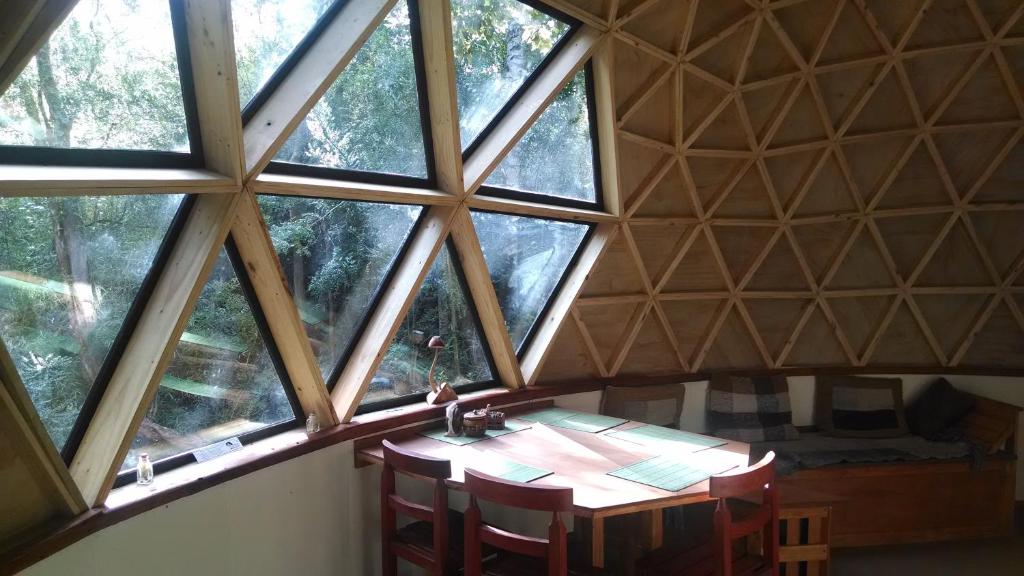 达卡卫多模博斯克乡村民宿的带木桌的客房,位于带窗户的房间内