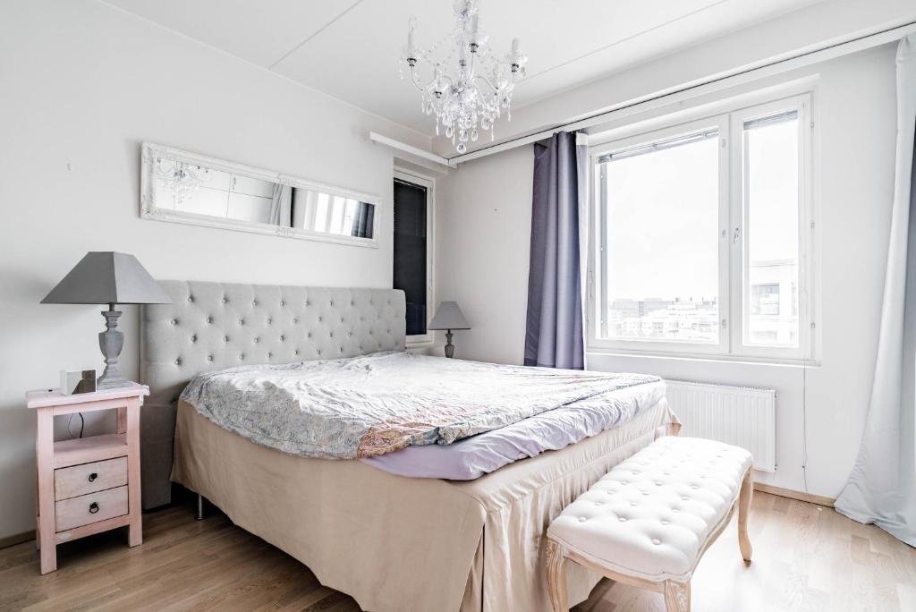 赫尔辛基Beautiful penthouse in the center of Helsinki的一间卧室配有一张床、一把椅子和一个吊灯。