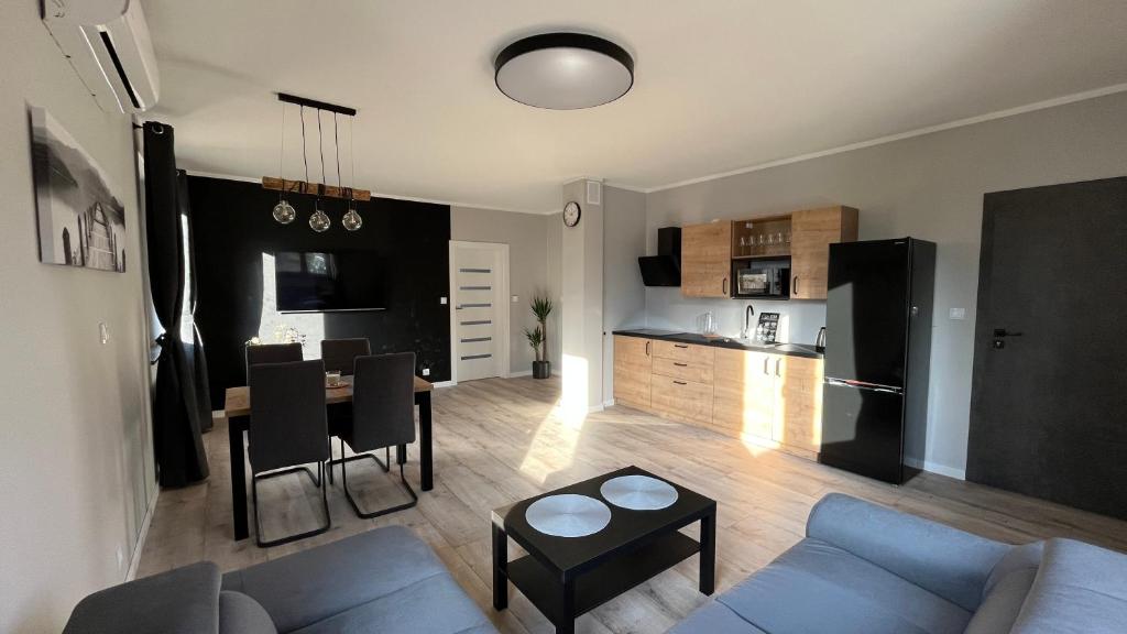 科瓦雷Apartamenty Czarna Perła的带沙发和桌子的客厅以及厨房。