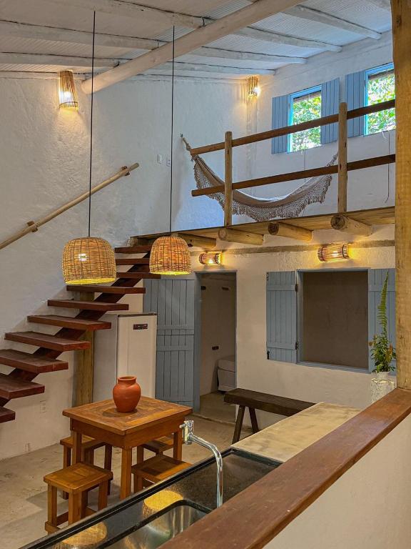 卡拉伊瓦Casinha do Rio的客房设有楼梯、桌子和吊床