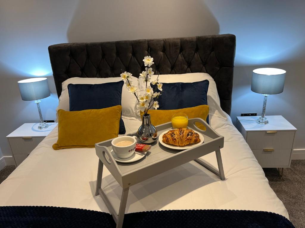斯凯格内斯The Penthouse - Luxury 2 Bed Apartment的一张桌子上带食物托盘的床
