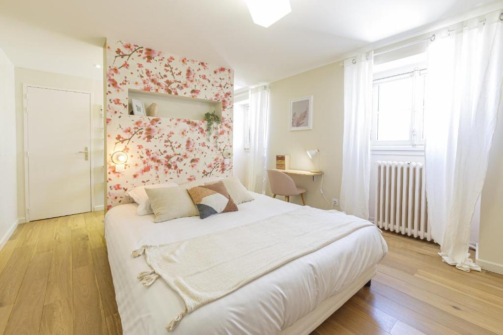 昂热Maison Bossoreil - Chambre Crémant的卧室配有一张白色大床和花卉墙