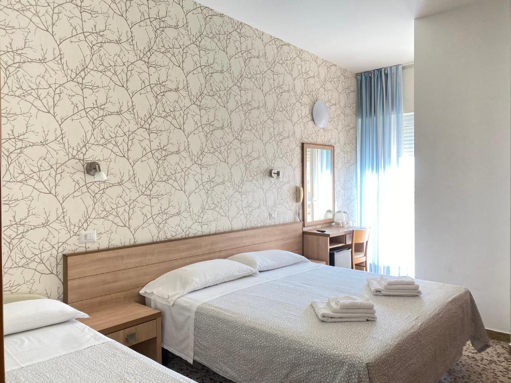 里米尼Hotel Ravello的一间卧室配有两张床和壁画