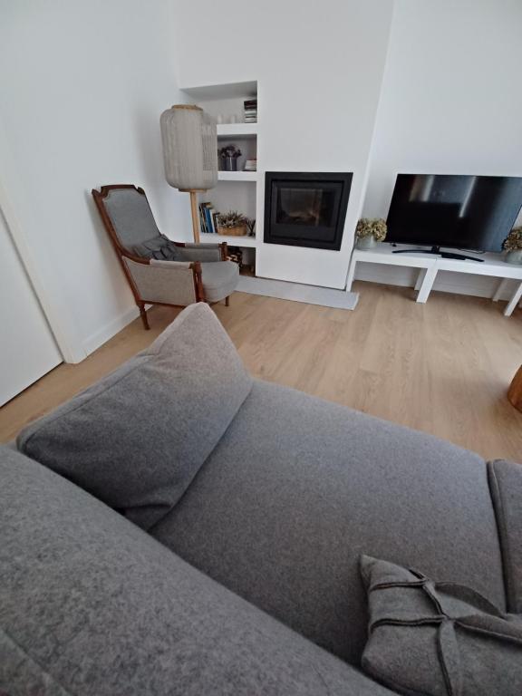 塞亚O 21 da Vila的客厅配有灰色的沙发和电视