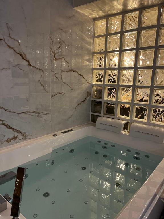 Triel-sur-SeineBulle Evasion的浴室设有按摩浴缸,配有葡萄酒瓶壁