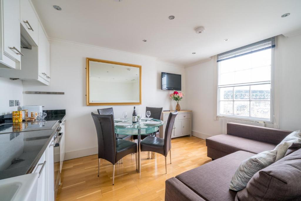 伦敦Camden Town Apartment的厨房以及带桌子和沙发的客厅。