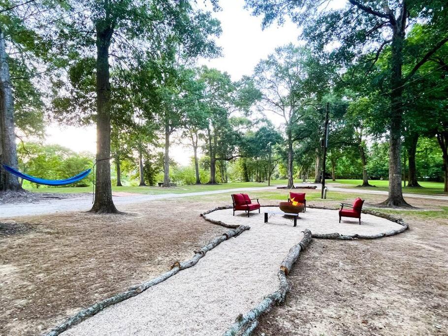 拉斐特Unwind & Relax at Azalea Cottage on Bayou的公园里两张红色的椅子和一张桌子