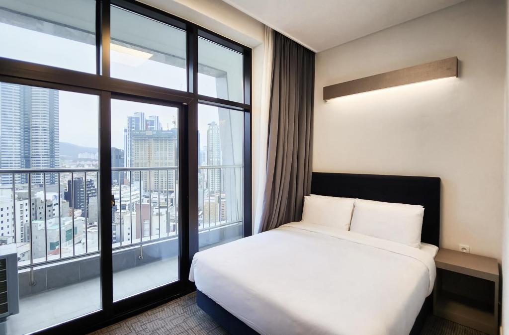 釜山Haeundae Blue Story Hotel的酒店客房设有一张床和一个大窗户