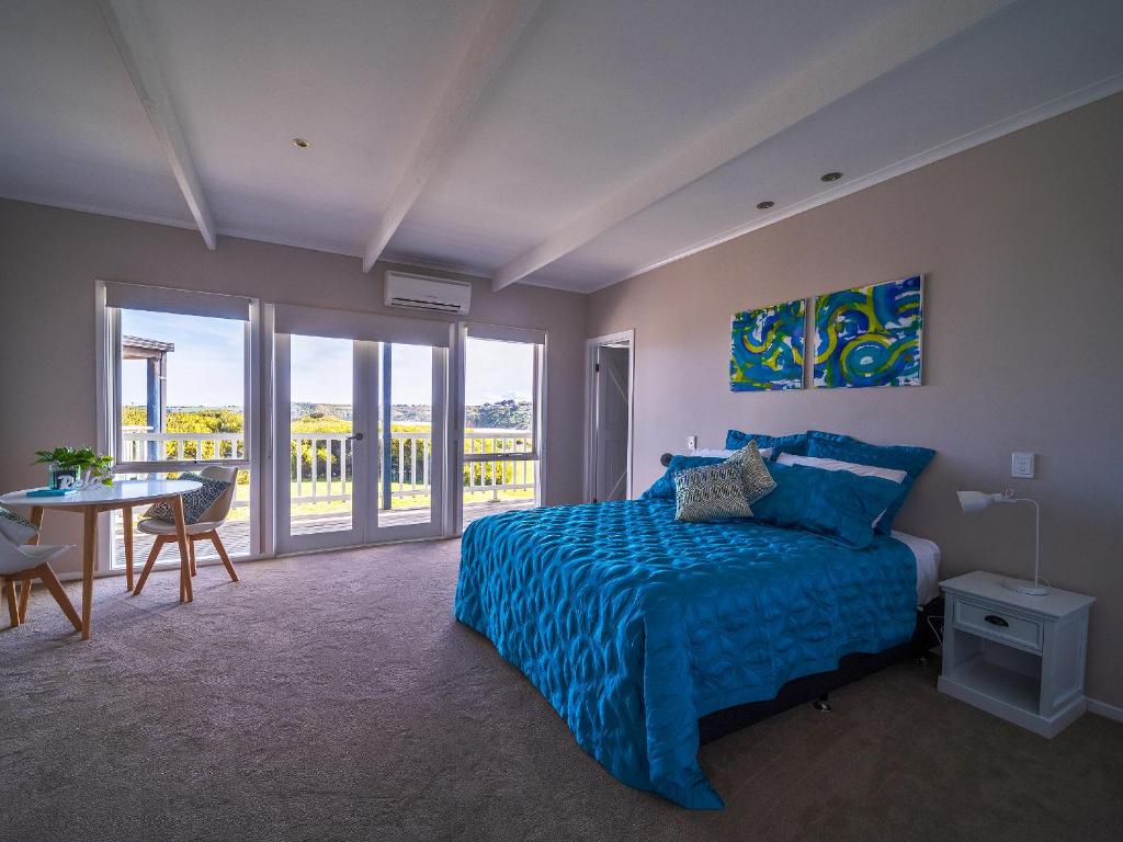 史密斯海滩1-bedroom unit with balcony and ocean views!的一间卧室配有蓝色的床和桌椅