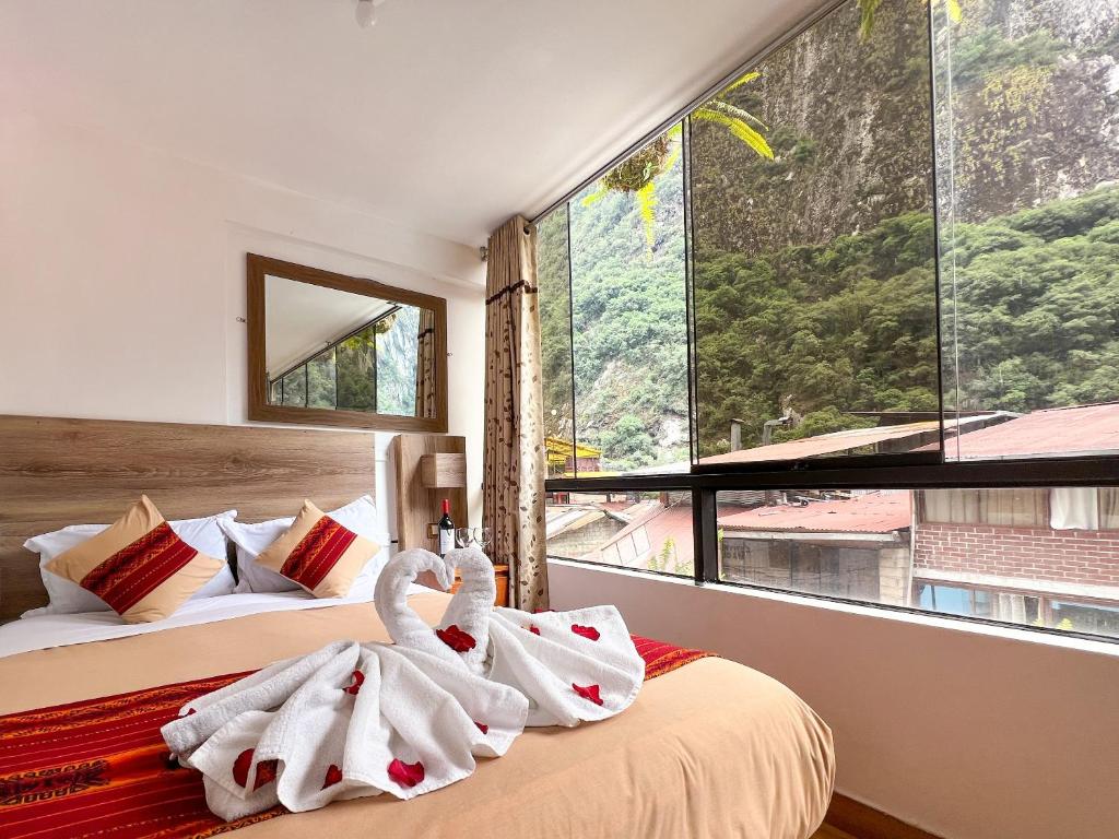 马丘比丘Runas Inn Machupicchu的一间卧室,床上配有2条天鹅毛巾