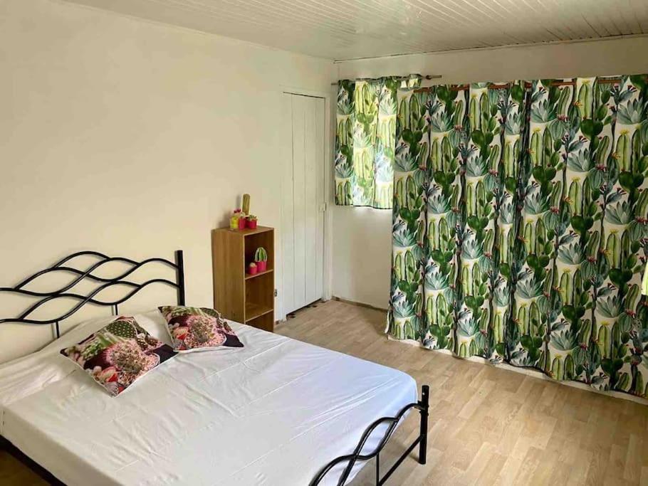 勒拉芒坦Maison chaleureuse avec terrasse et parking privé的一间卧室配有一张带白色床单和窗帘的床