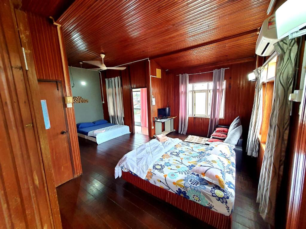 瓜拉丁加奴Homestay Kuala Terengganu One Stop 1的木制客房内的一间卧室,配有一张床