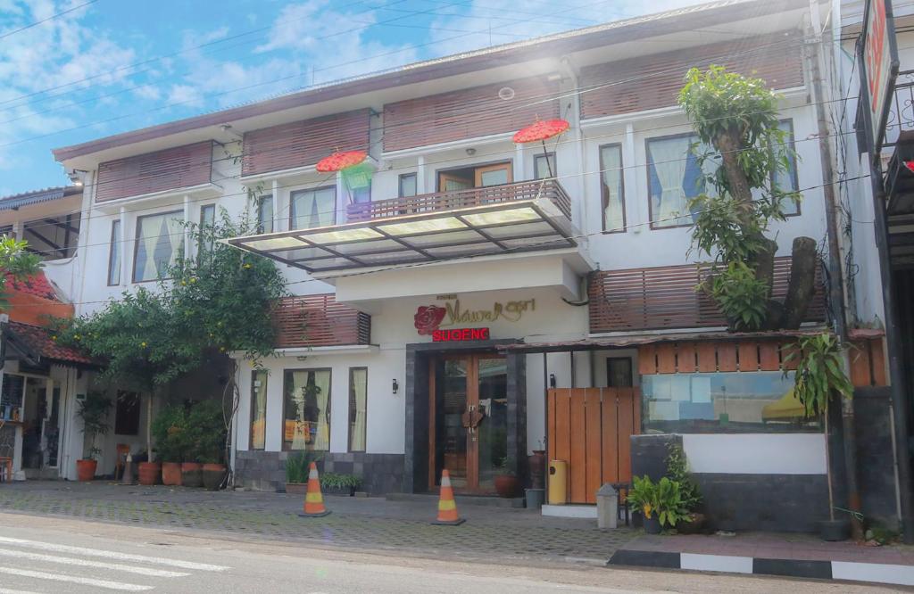 日惹Mawar Asri Hotel的一条街道上的建筑,前面有橙色的锥形