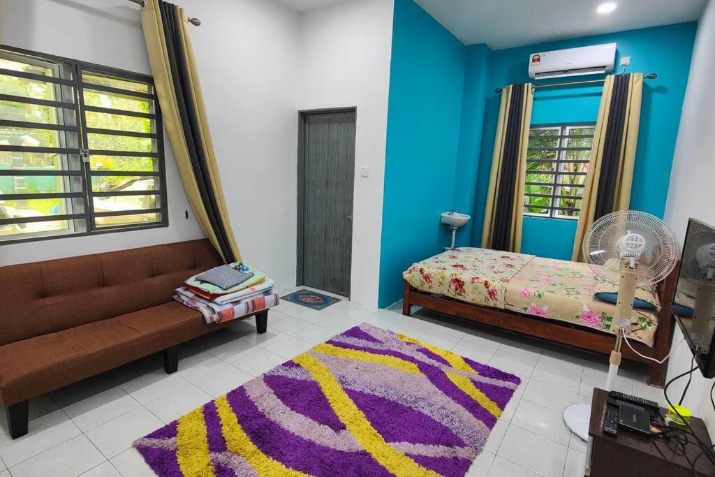 淡马鲁Homestay D Paya Jauh的一间配有沙发和床及地毯的房间